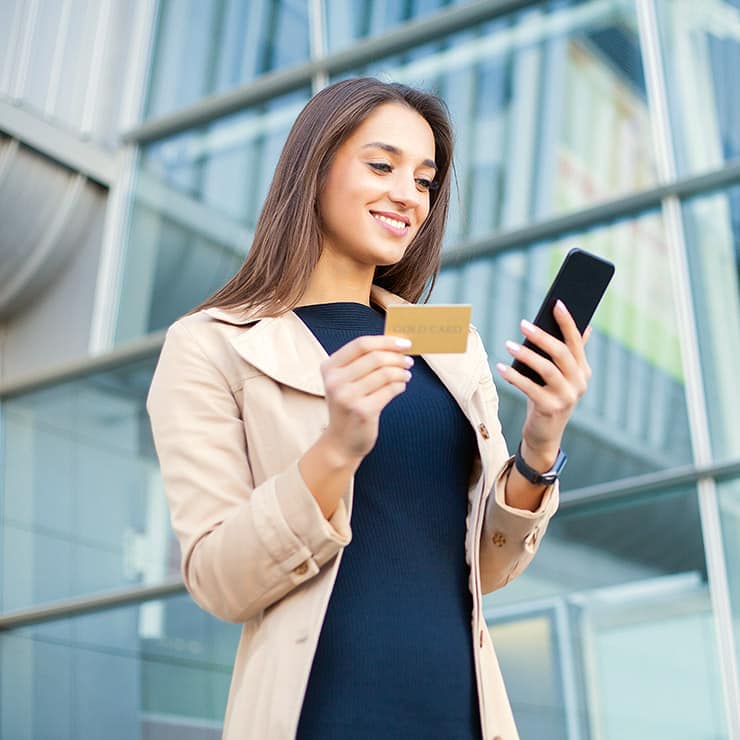 Jeune femme réservant une villa avec sa carte de crédit