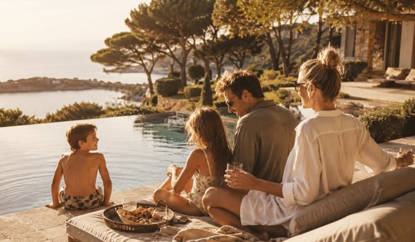 Family enjoying a summer vacation by the pool of a luxury villa on the French Riviera